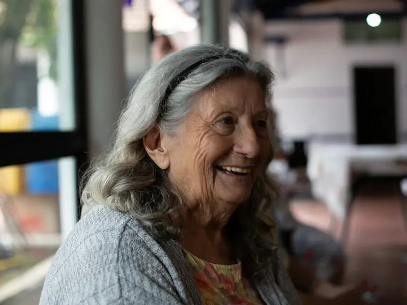 Femme âgée souriante, en lumière naturelle