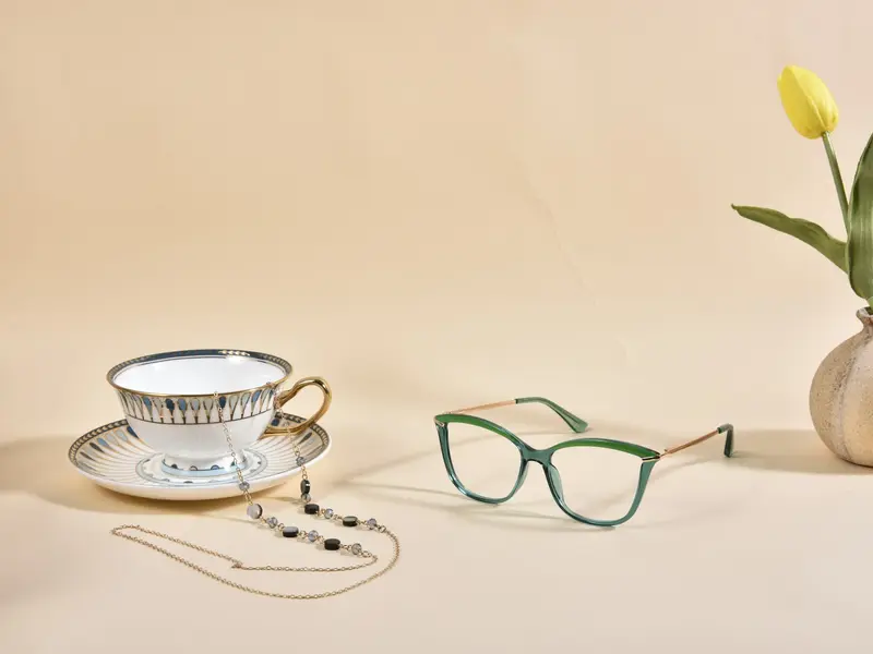 Paire de lunettes posée près d'une tasse et d'une fleur